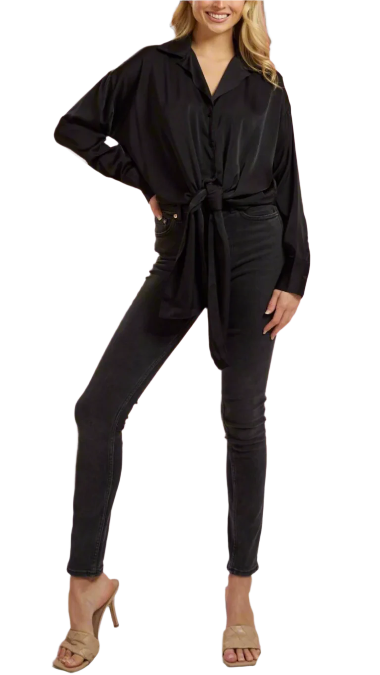 Woman wearing a black shirt with a tie waist against a gray background