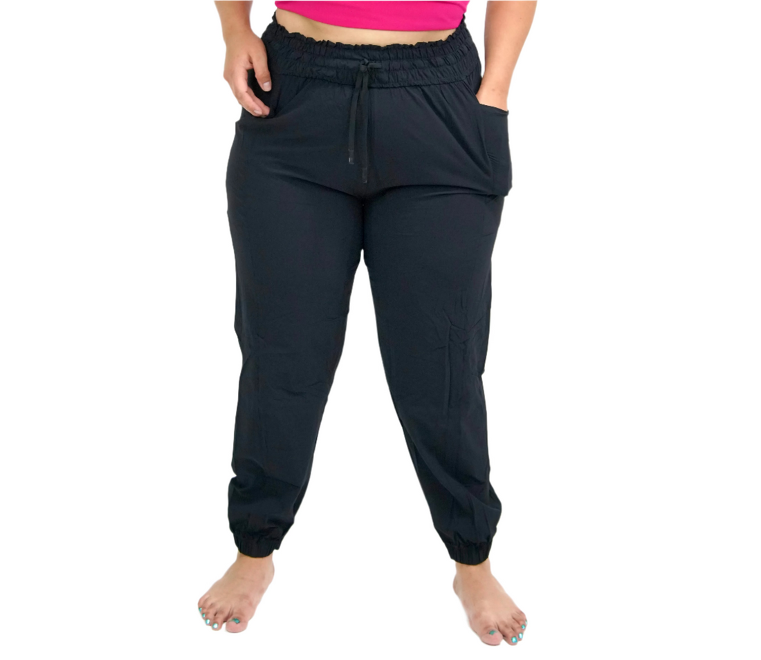 A pair of black relaxed joggers with a drawstring waist, featuring side pockets below the waistband.