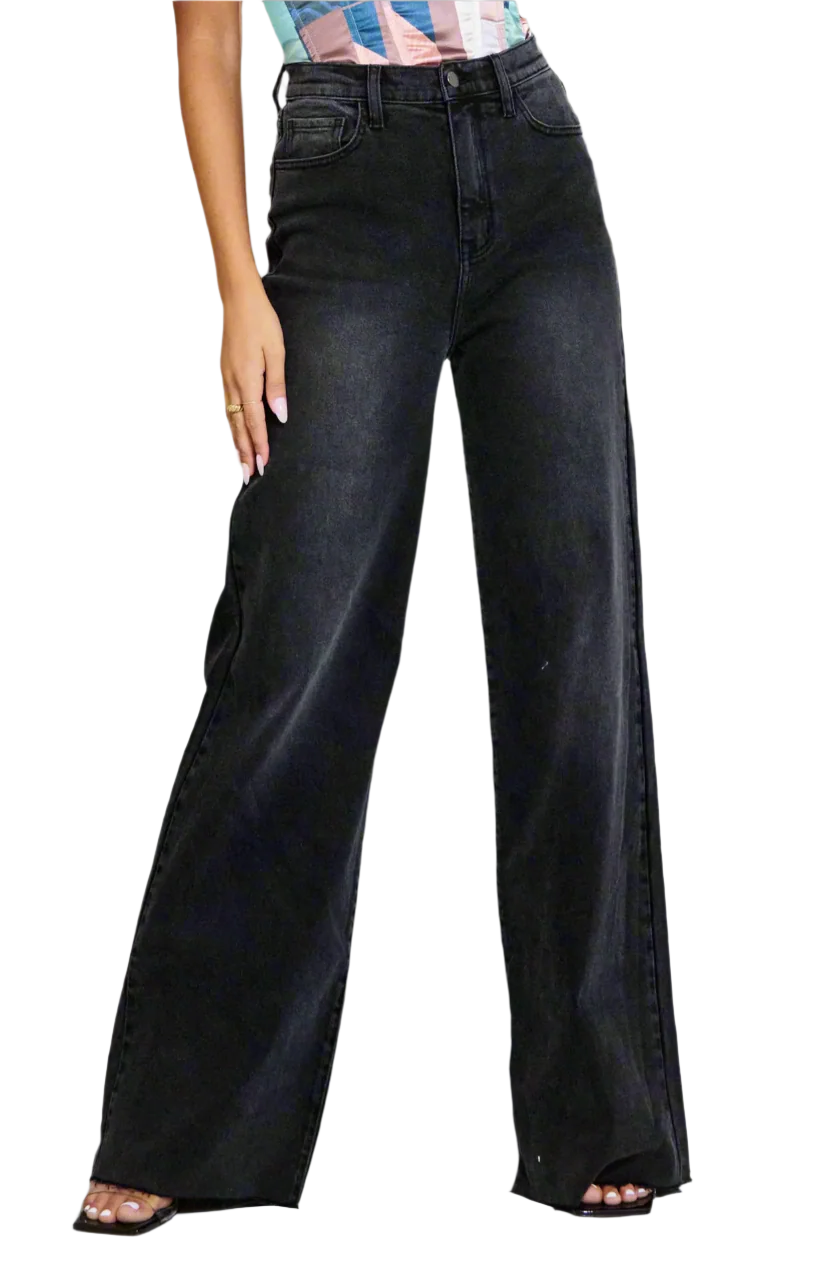 Person wearing black wide-leg jeans against a neutral background