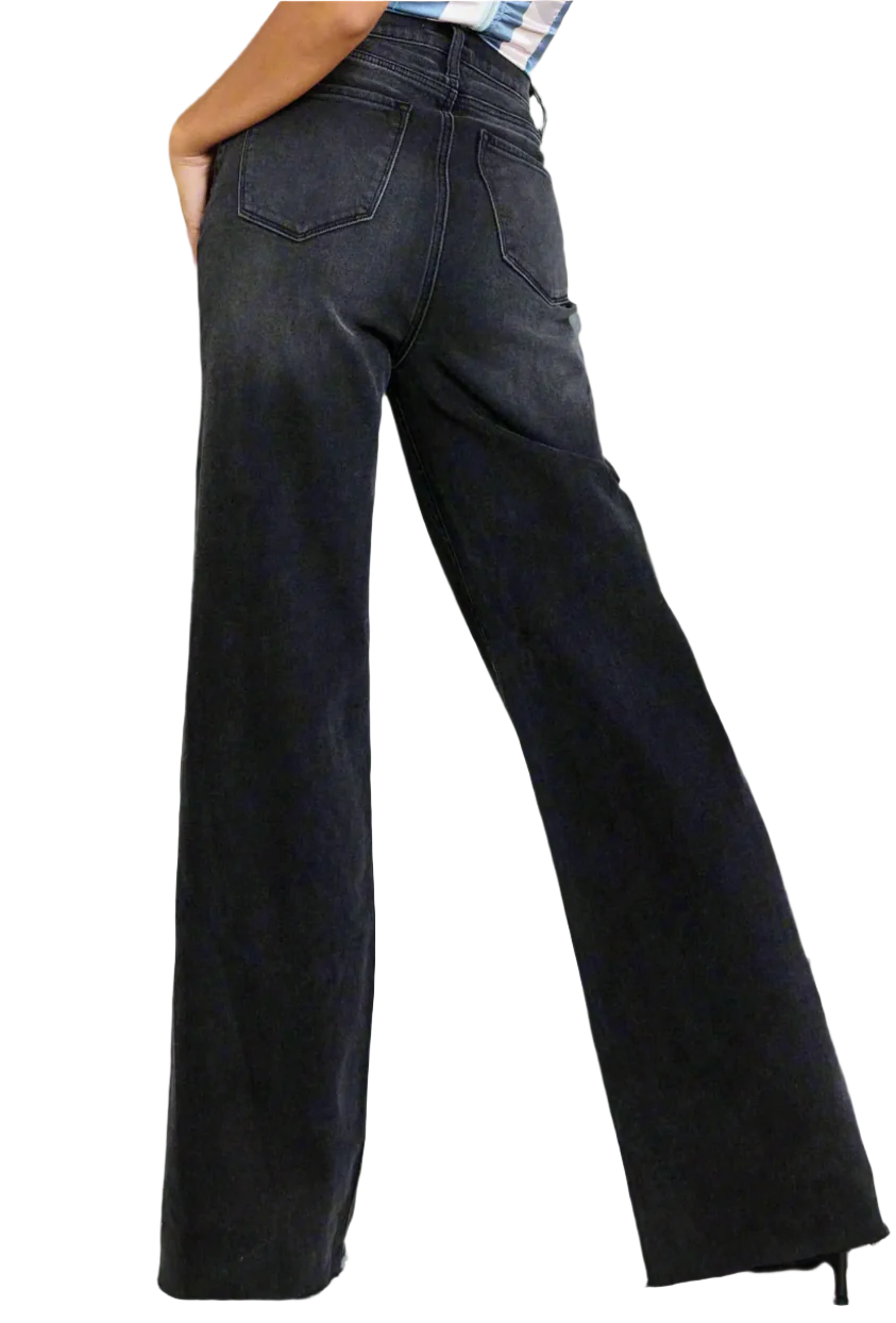 Person wearing black wide-leg jeans against a neutral background