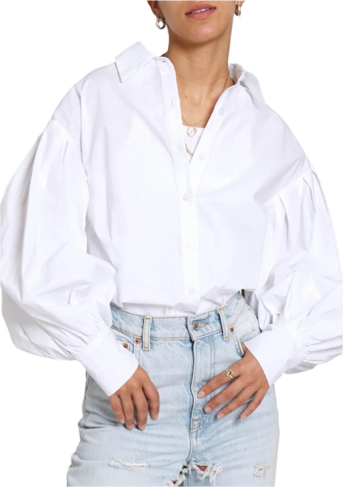 A person wearing a white pleated balloon sleeve button-down shirt and blue jeans.