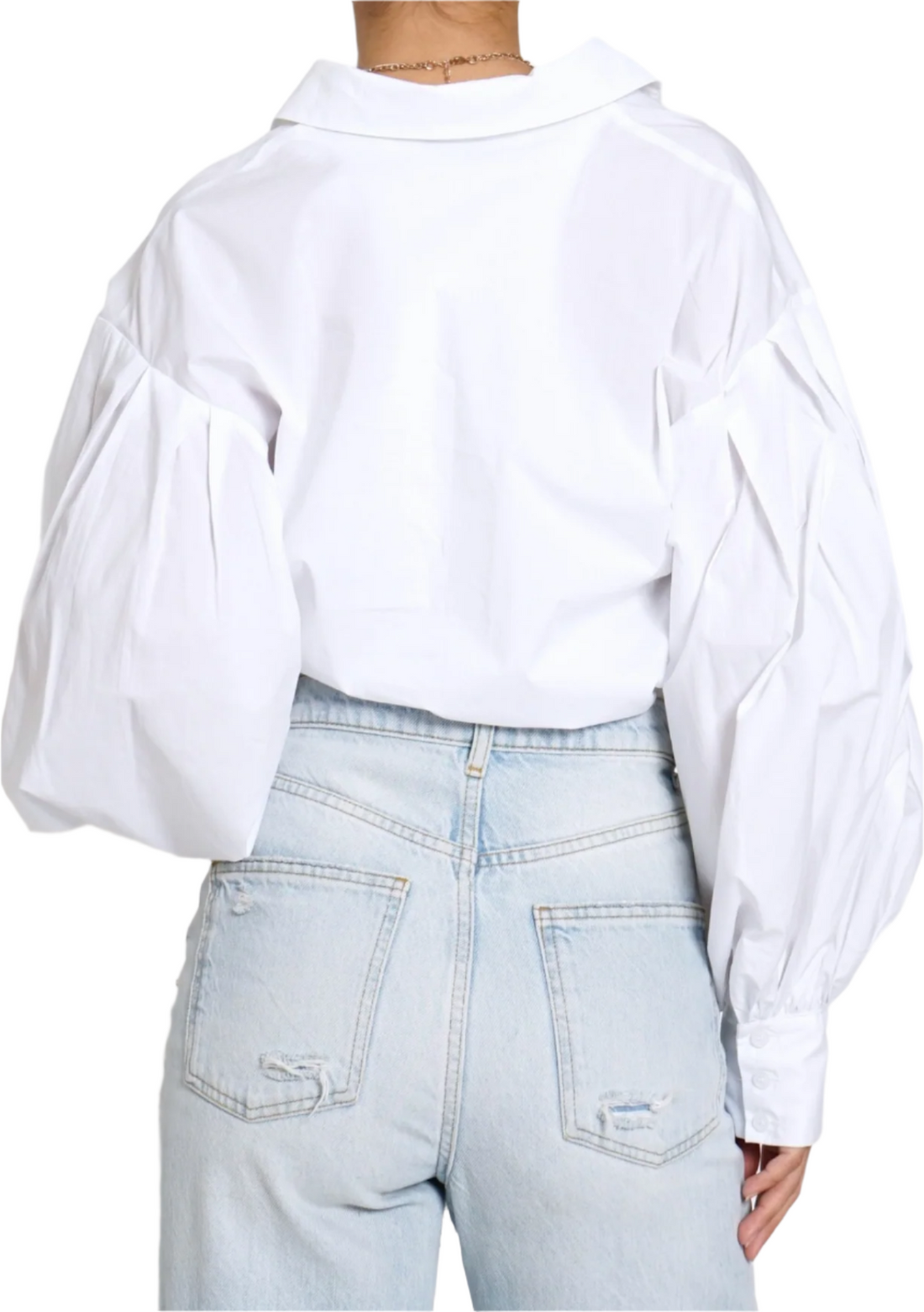 A person wearing a white pleated balloon sleeve button-down shirt and blue jeans.