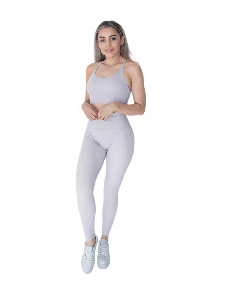 Woman wearing a gray athletic outfit on a white background