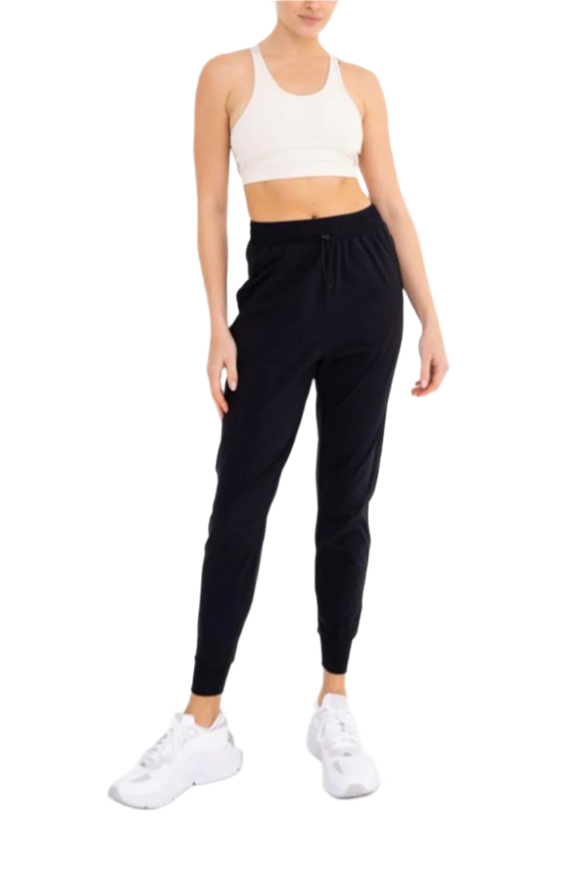 Person wearing a white sports bra and black leggings on a white background