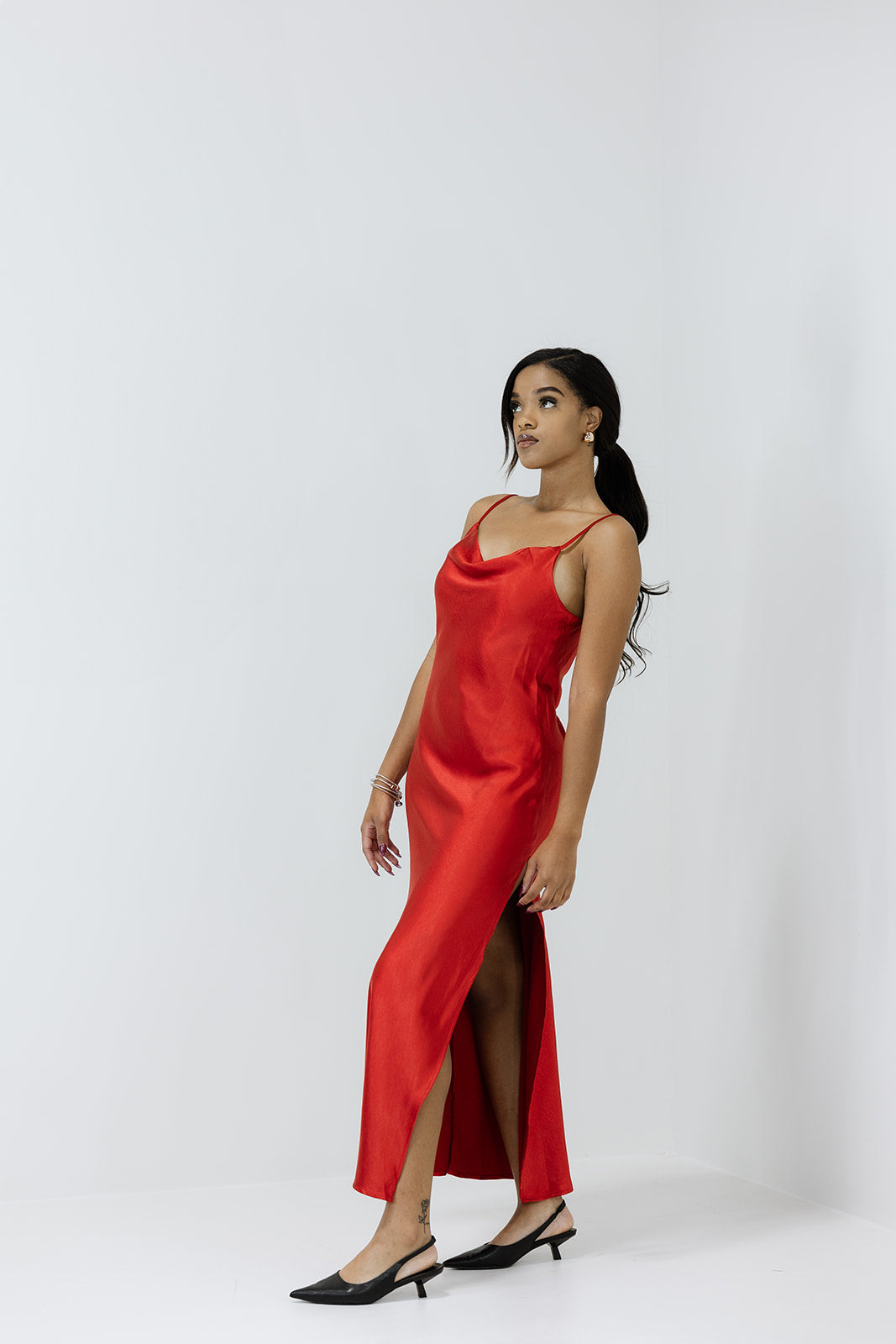 Red satin slip dress worn by a model on a white background