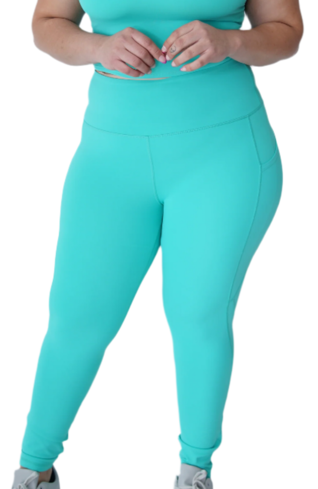 Woman wearing a turquoise athletic outfit on a white background