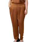 A person standing wearing brown trouser pants with elastic and pockets.