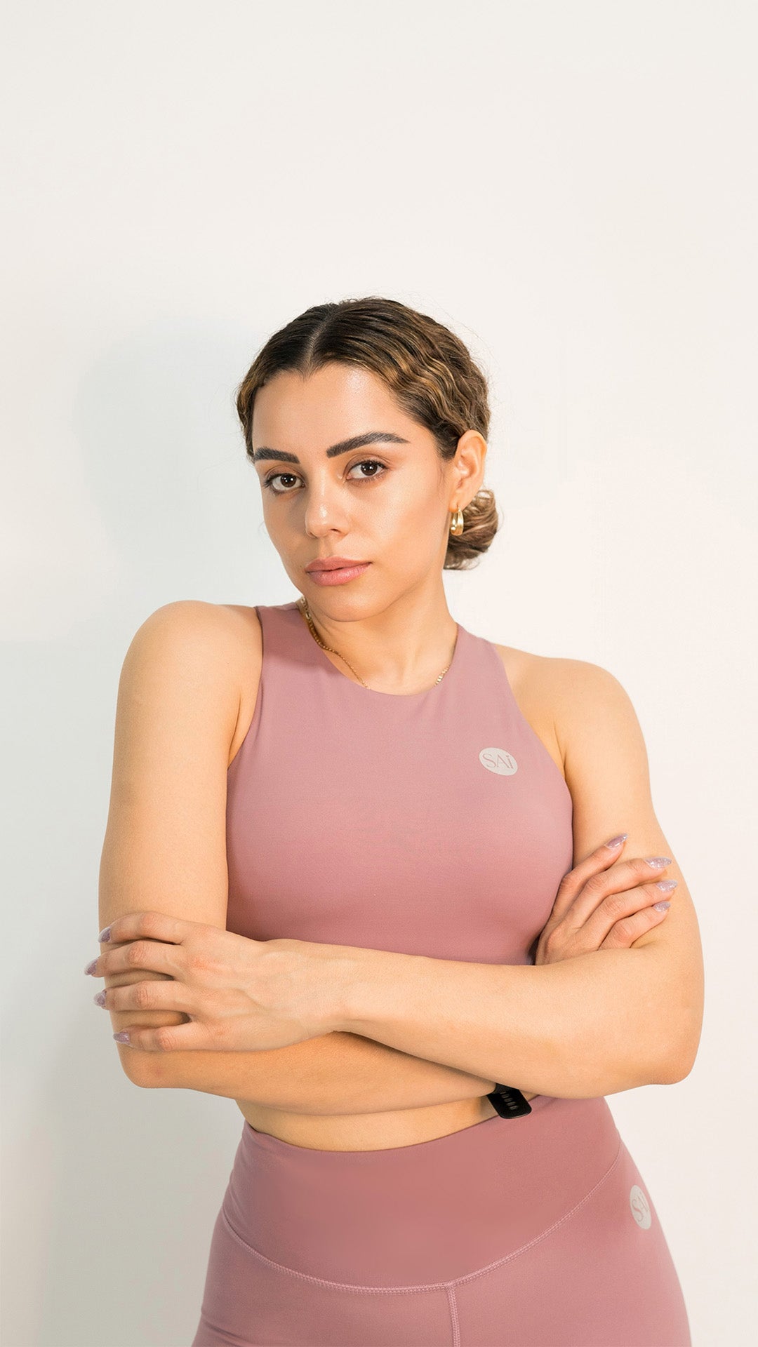 Woman wearing a pink athletic outfit on a white background