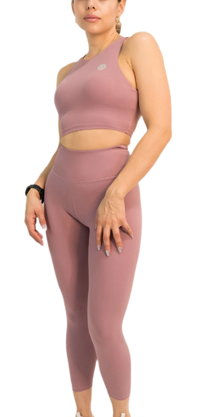 Woman wearing a pink athletic outfit on a white background