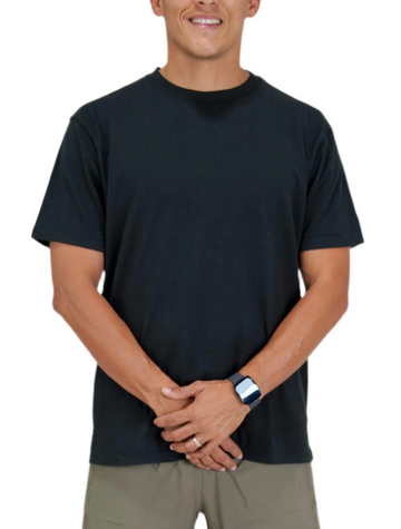 Man wearing a black t-shirt and beige shorts on a white background