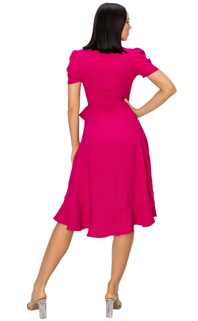 A woman wearing a pink, V-neck, sleeveless, midi dress with a flowing hemline, paired with ankle strap sandals.