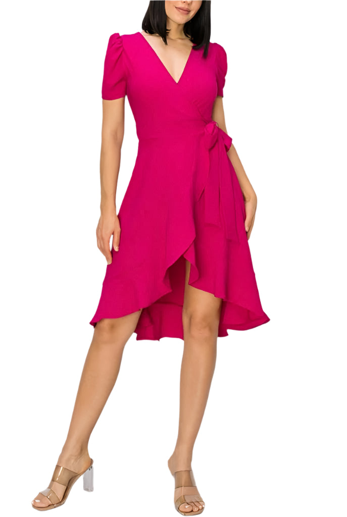A woman wearing a pink, V-neck, sleeveless, midi dress with a flowing hemline, paired with ankle strap sandals.