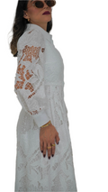 Woman wearing a white lace dress with long sleeves on a white background