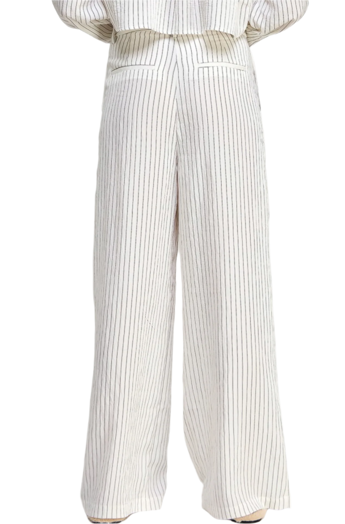 A model wearing full-length men's pants with black lines on a white background, standing against a white background.