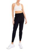 Person wearing a white sports bra and black leggings on a white background