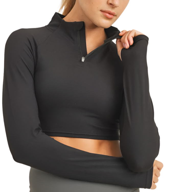 Woman wearing a black long-sleeve crop top with a zipper on a white background