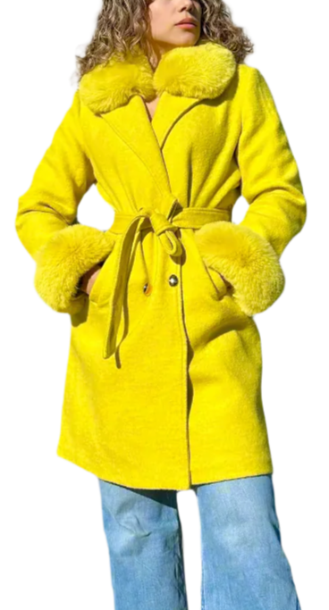 Person wearing a bright yellow coat with a fur collar on a plain background
