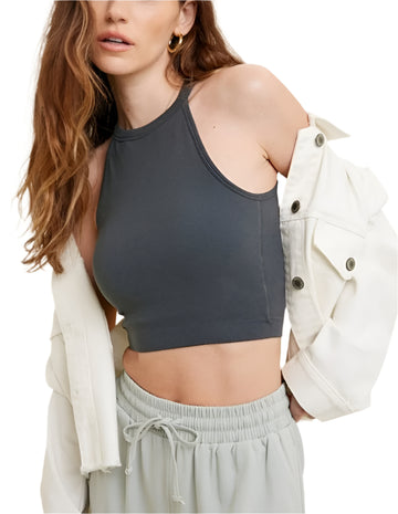 A woman wearing a seamless ribbed high neck top in gray, with a necklace and a white jacket over it.