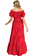 Woman wearing a red off-shoulder dress with puff sleeves on a gray background
