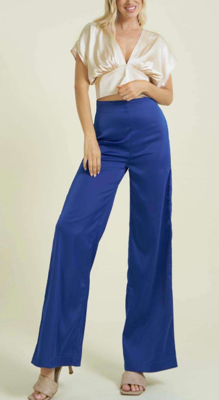 Woman wearing a white top and blue pants on a white background