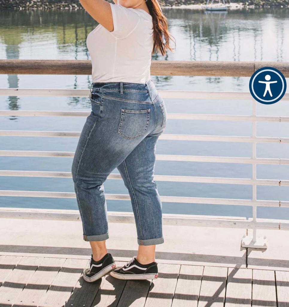 Person wearing blue jeans and a white top on a gray background