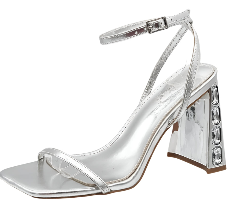 A pair of silver block heel sandals with tubular straps and a square toe, on a white background.