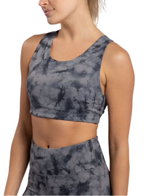 Person wearing a gray tie-dye sports bra and leggings on a white background