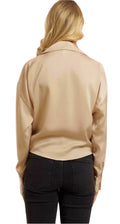 Person wearing a beige jacket on a pink background